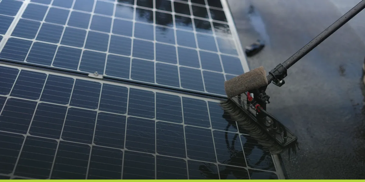 A technician inspecting the surface of a solar panel closely during a site check