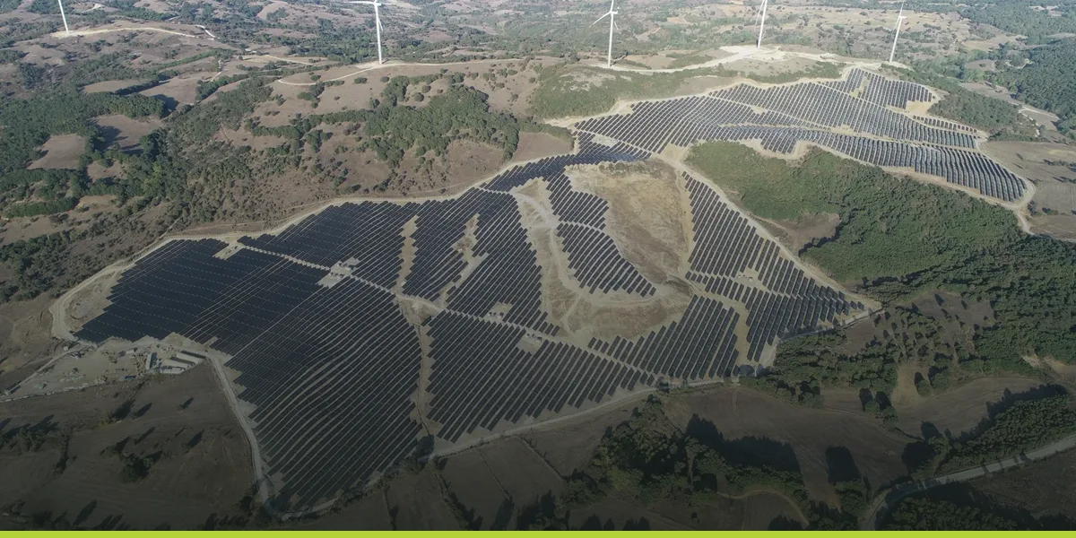 Aerial view of a hybrid solar plant, its panel rows following the hillside contours
