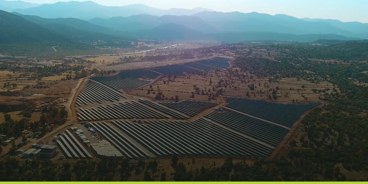 Aerial view of a utility-scale solar power plant built across a valley floor